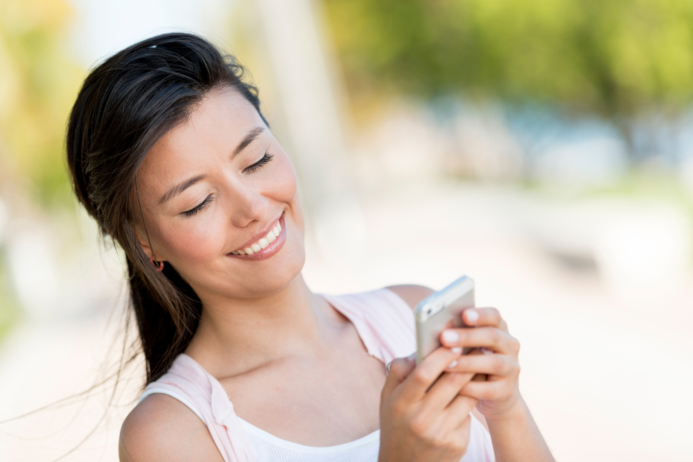 Woman Texting On A Smart Phone Looking Happy